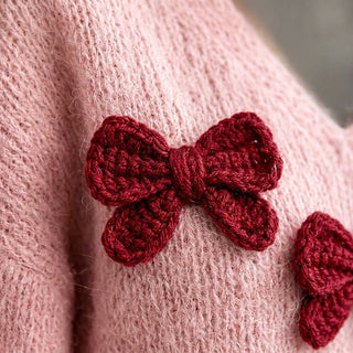 Kotori - Gros plan sur la maille rose et le nœud au crochet bordeaux