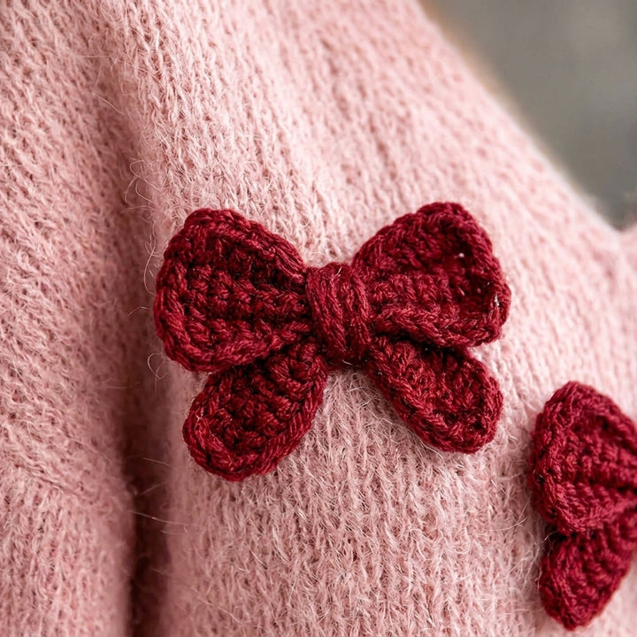Kotori - Gros plan sur la maille rose et le nœud au crochet bordeaux
