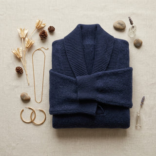 Mise en valeur du pull Chihiro bleu nuit plié avec accessoires